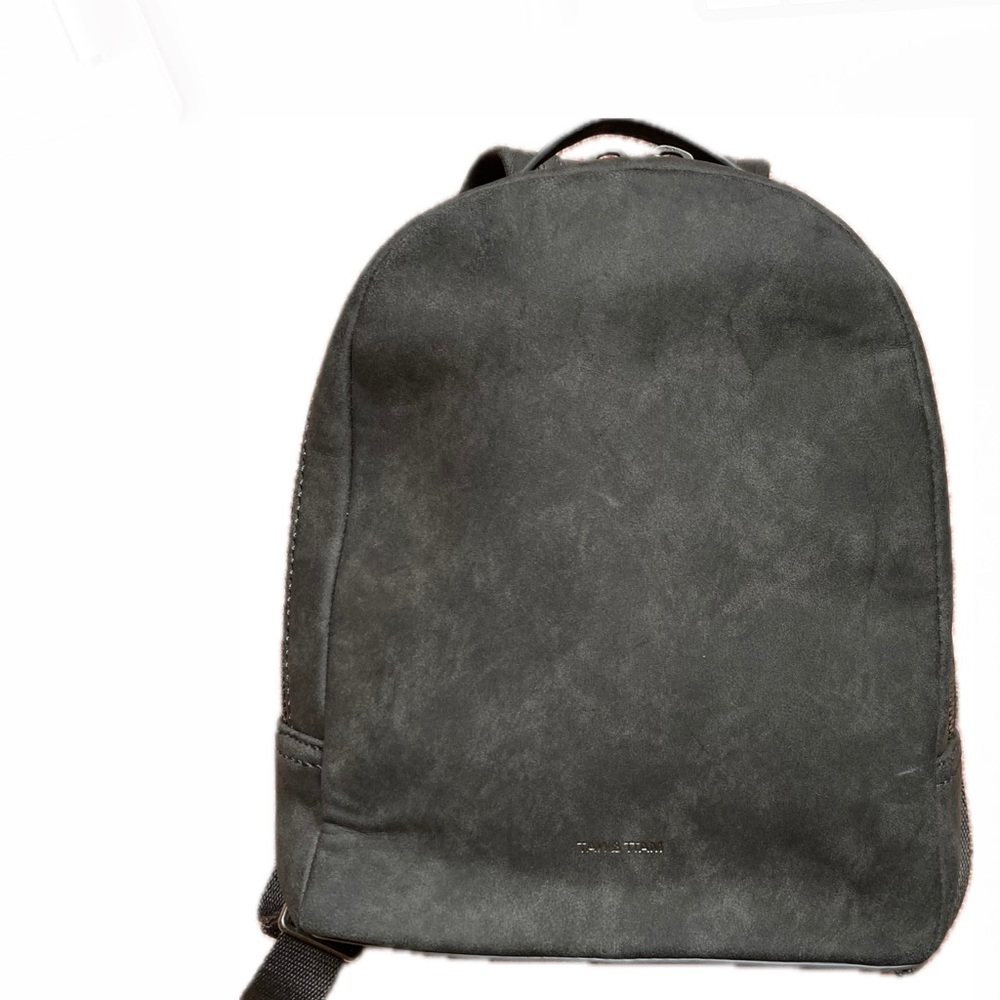 Small backpack with straps and metal zippered opening. Exterior back pocket.